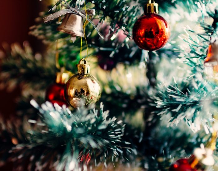 Gros plan sur un sapin et quelques boules de Noël. 