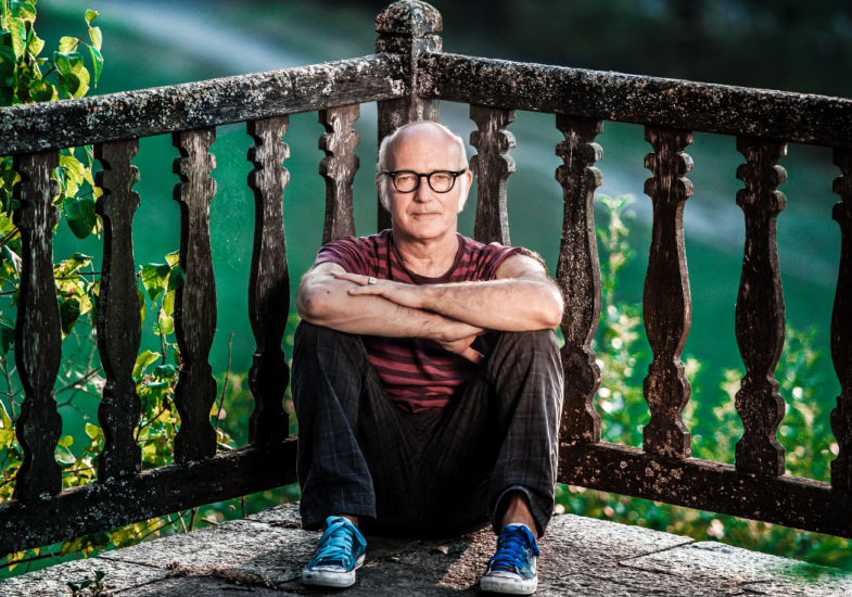 Le musicien Ludovico Einaud est assis par terre, près de la rampe d'un balcon. 
