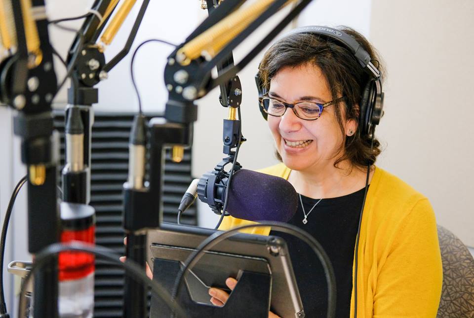 Hélèene Denis, au micro, avec des écouteurs lit un article sur une tablette électronique Hélèene Denis, au micro, avec des écouteurs lit un article sur une tablette électronique