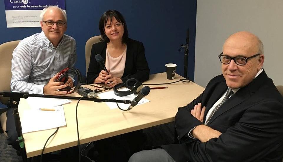 Michel Poulin, Diane Felice et Francis Guiteau à une table avec des micros lors de l'enregistrement de l'entrevue.  