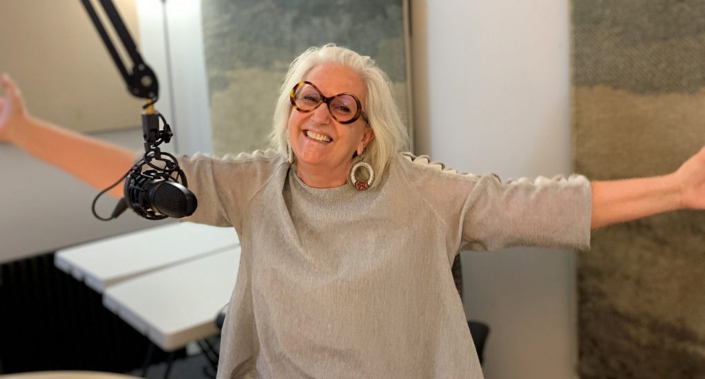 Arlette Fara, en studio, souriante les bras ouverts Arlette Fara, en studio, souriante les bras ouverts