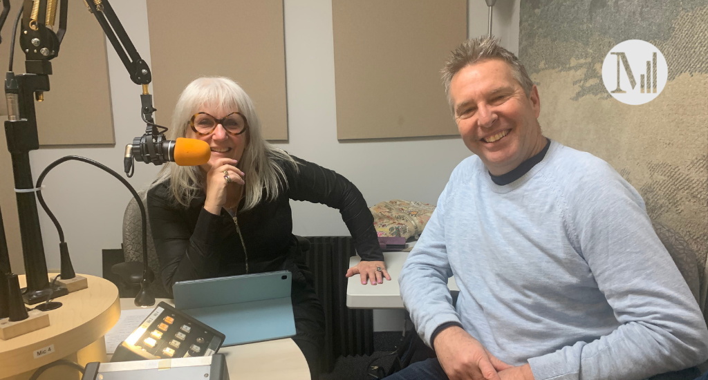 Arlette et son invité Pierre Svartman dans le studio de Canal M. Arlette est accoudée sur la table et Pierre Svartman est adossé sur la chaise, souriant. 