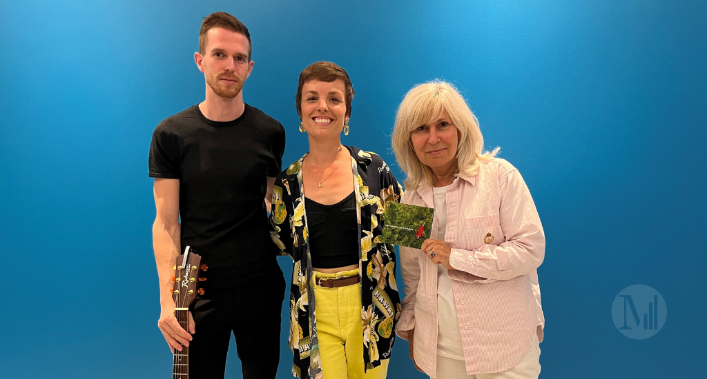 Lucie-Valentine et son guitariste posent avec Chantal Lavoie devant un mur bleu.