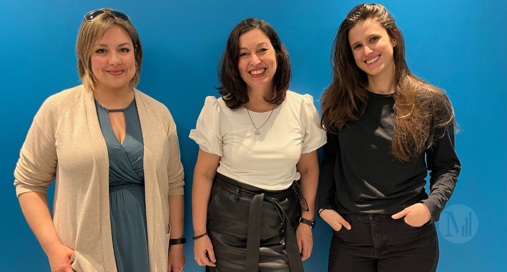 Chantal Dauray, Mélissa St-Louis et Fran Delhoume posent devant un mur bleu.