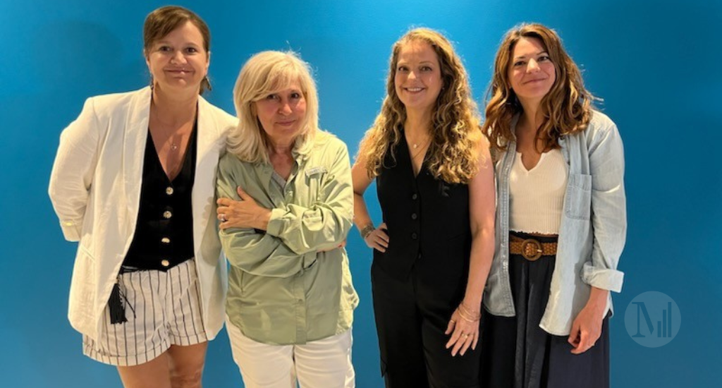 Nathalie Barrette, Chantal Lavoie, Guylaine Maroist et Catherine Renaud prennent la pose devant un mur bleu. 