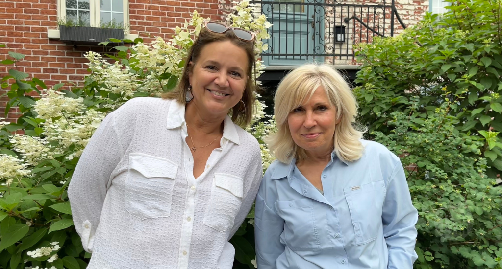 Chantal et Nathalie posent devant des fleurs blanches.