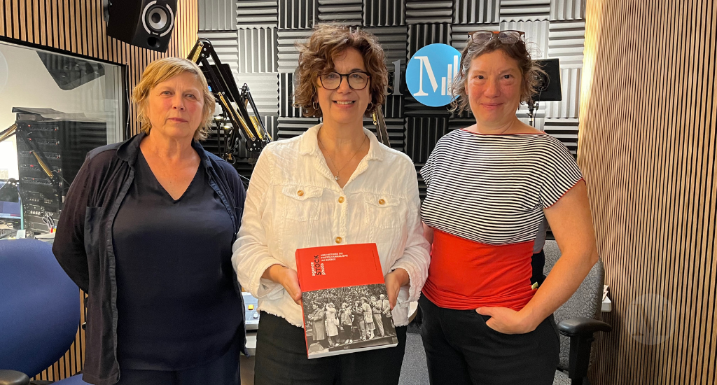 Hélene Denis pose debout en studio avec ses deux invitées,  Jocelyne Fournel et Caroline Hayeur, un livre à la main.