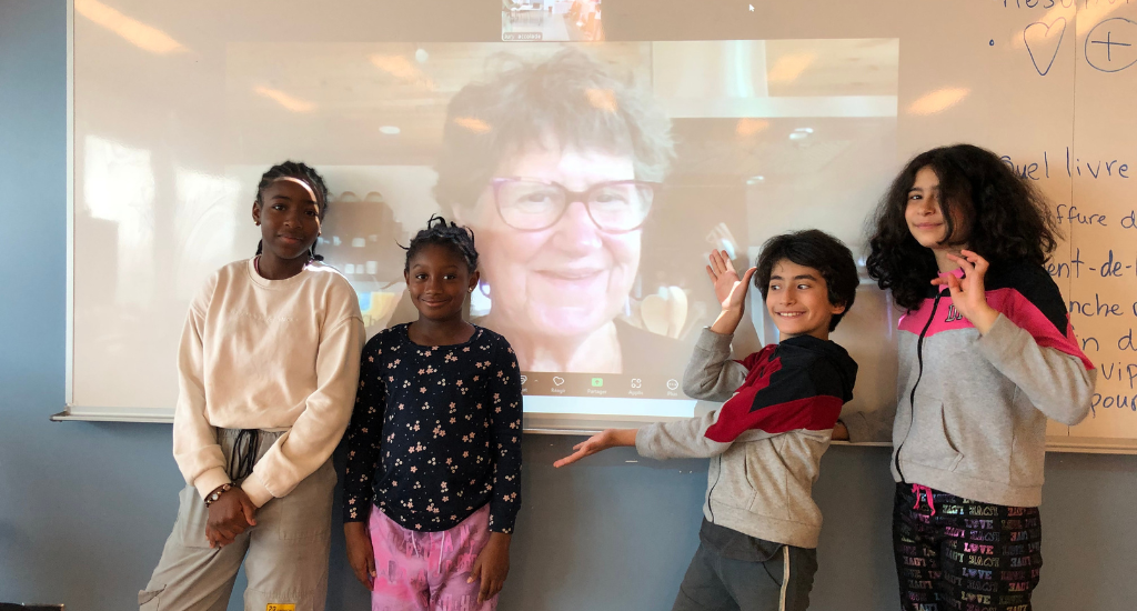 Enfants du Camp Accolades en classe. Portrait de Marie Lalande projeté sur le tableau blanc.