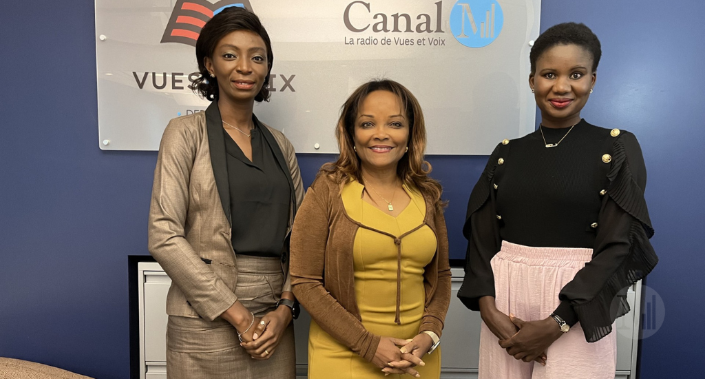 Grace Oulaï, Marjorie Théodore et Elima Diabong posent devant le panneau publicitaire de Vues et Voix. 