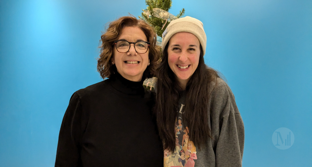 Hélène Denis et Monika Pilon posent devant un mur bleu.