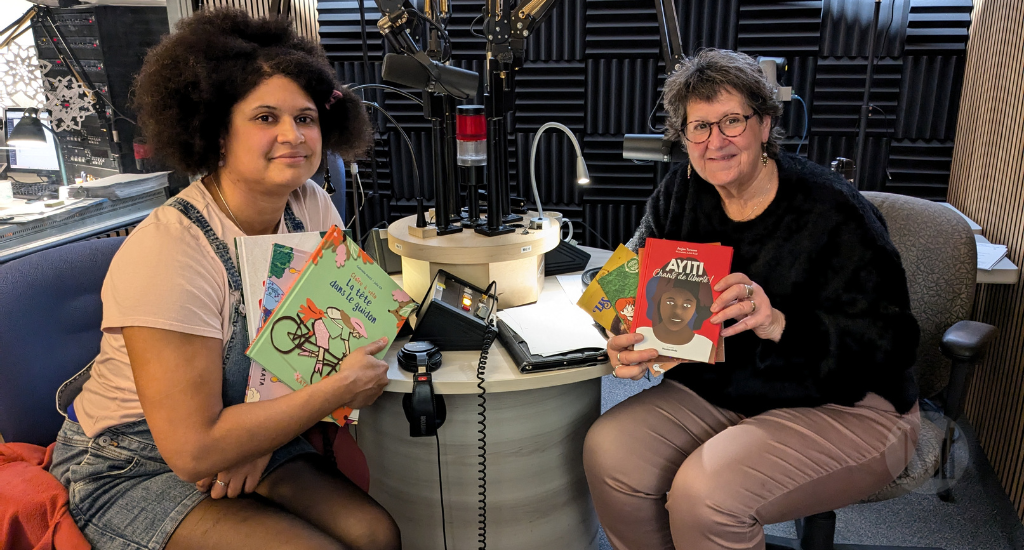 Marie Lalande pose assise en studio avec Anne Laure Jean et plusieurs albums jeunesse.