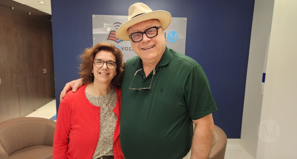 Hélène Denis et Jean-Bernard Hébert prennent la pose devant le panneau publicitaire de Vues&Voix/Canal M. 